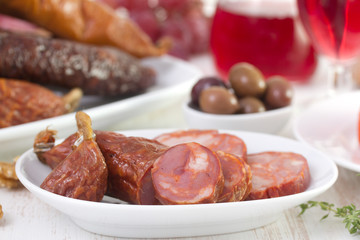 chourico on white dish with wine and olives
