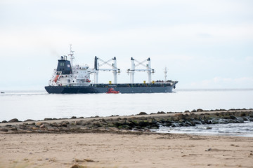 cargo ship is leaving port sailing away