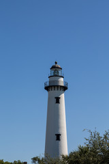 White Brick Lighthouse with Black Iron Hardware Under Blue Skies