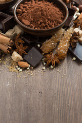 spices for hot chocolate on a wooden background, vertical