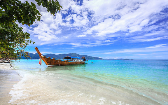 Longtail boat on crystal clear sea at tropical beach