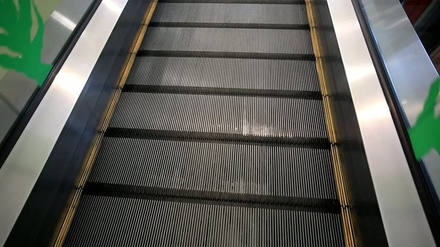 Moving down escalator in market. HD. 1920x1080