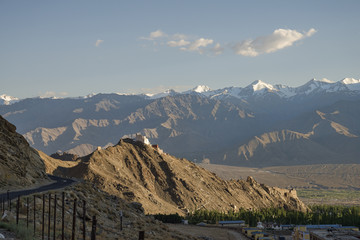 Ancient casttle on cliff among high mountains and green valley