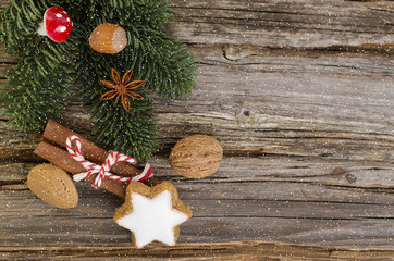 Hintergrund mit Tannengrün, Zimtstern, Zimtstangen und Nüssen