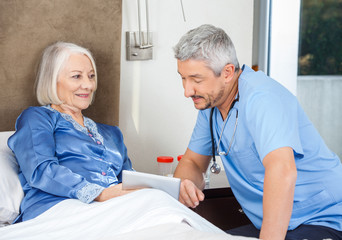 Obraz premium Caretaker And Senior Woman Using Tablet PC