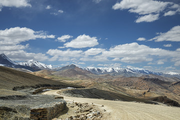 View of curved road among snow capped mountains
