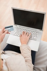 Blonde woman using laptop on couch