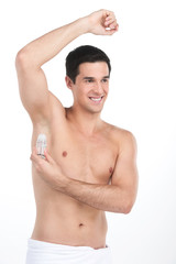 Fototapeta premium Young handsome men applying deodorant on armpits.
