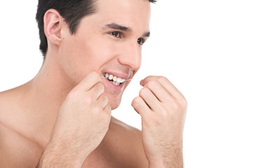 young man flossing his teeth isolated on white background.