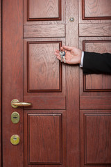 man holding keys to apartment door.