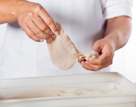 Butcher Adding Flour To Chicken Meat