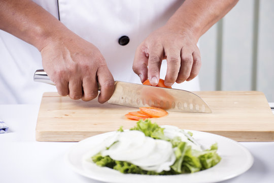 Chef's hands cutting Tomato