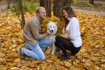 Fototapeta premium Young couple with a dog in the autumn forest