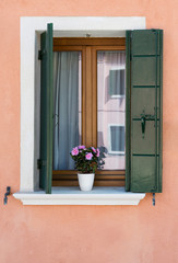Fototapeta na wymiar Window with green shutters. Burano . Venice. Italy