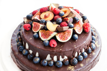 Chocolate cake with icing, decorated with fresh fruit