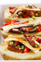 Baked potatoes stuffed with bacon, served with camembert