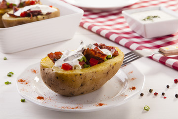 Baked potatoes stuffed with bacon served with dill sauce