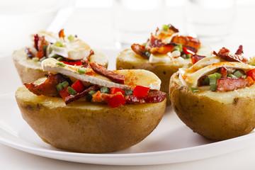Baked potatoes stuffed with bacon, served with camembert