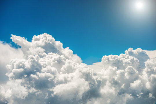 Fototapeta Fototapeta Białe chmury, czyste niebo, jasne słońce optycznie powiększająca