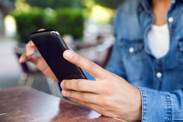 Modern young man with mobile phone in the street.