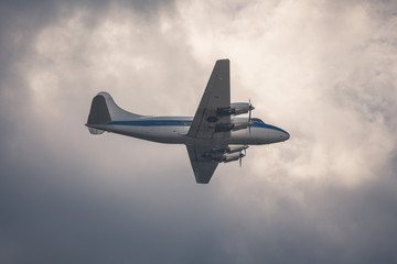 Old passenger plane on cloudy sky