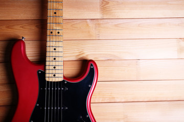 Fototapeta premium Red guitar on wooden background