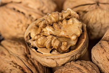 Whole walnuts and walnut kernel in a wicker basket close-up