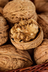 Whole walnuts and walnut kernel in a wicker basket close-up