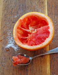 Sliced grapefruit with sugar on wooden plank