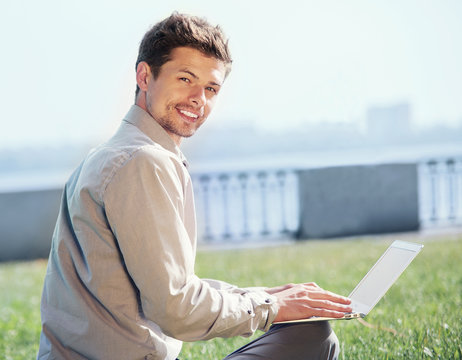 Young man with laptop outdoor portrtait