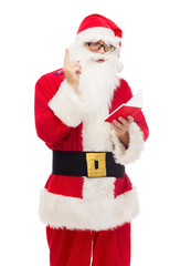 Naklejka premium man in costume of santa claus with notepad