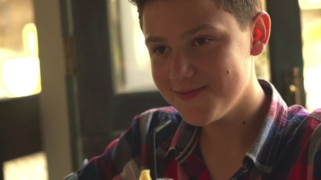 Young teenager drinking refreshing juice in cafe