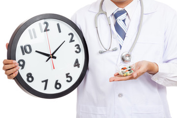 Asian male doctor show a clock and pills
