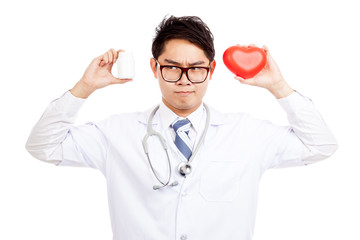 Asian male doctor think with red heart and pill bottle