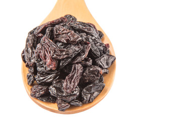 Black raisin on wooden spoon over white background