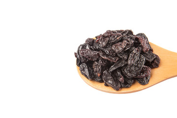 Black raisin on wooden spoon over white background