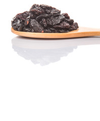 Black raisin on wooden spoon over white background