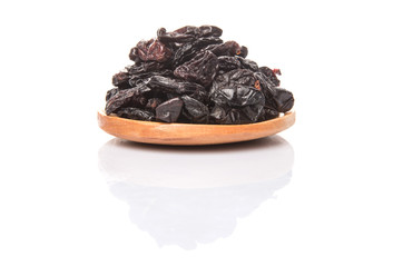 Black raisin on wooden spoon over white background