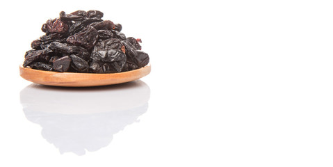 Black raisin on wooden spoon over white background