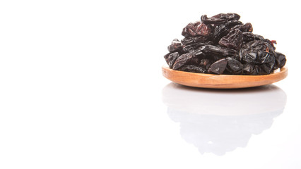 Black raisin on wooden spoon over white background