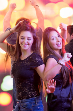 two young girls dancing in a club