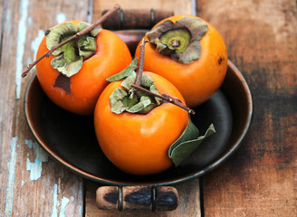 Fresh ripe persimmon on a wooden table
