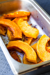 slices of baked pumpkin with honey in a metal bowl