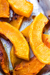slices of baked pumpkin with honey in a metal bowl
