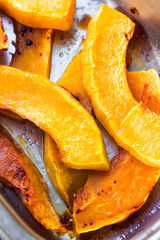 slices of baked pumpkin with honey in a metal bowl