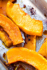 slices of baked pumpkin with honey in a metal bowl