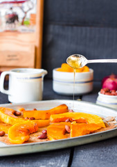pour honey roasted pumpkin slices with cinnamon on parchment