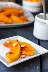 Baked pumpkin with honey and nuts on a white plate