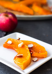 Baked pumpkin with honey and nuts on a white plate