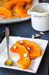 baked pumpkin slices with cinnamon and nuts, spoon with honey
